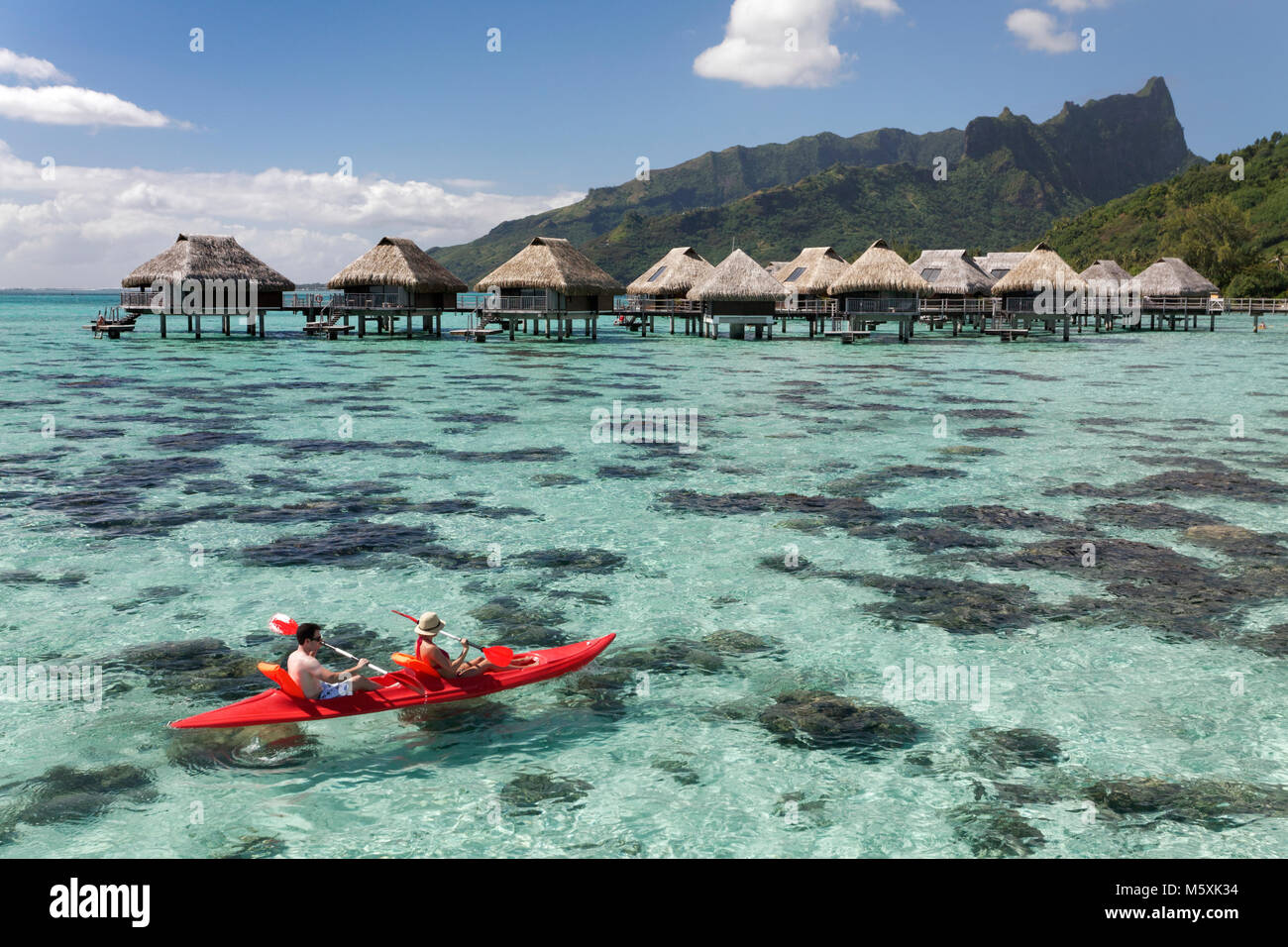 Lagoon, water bungalows, paddleboat, hills, Moorea, Pacific Ocean, Society Islands, French Polynesia Stock Photo