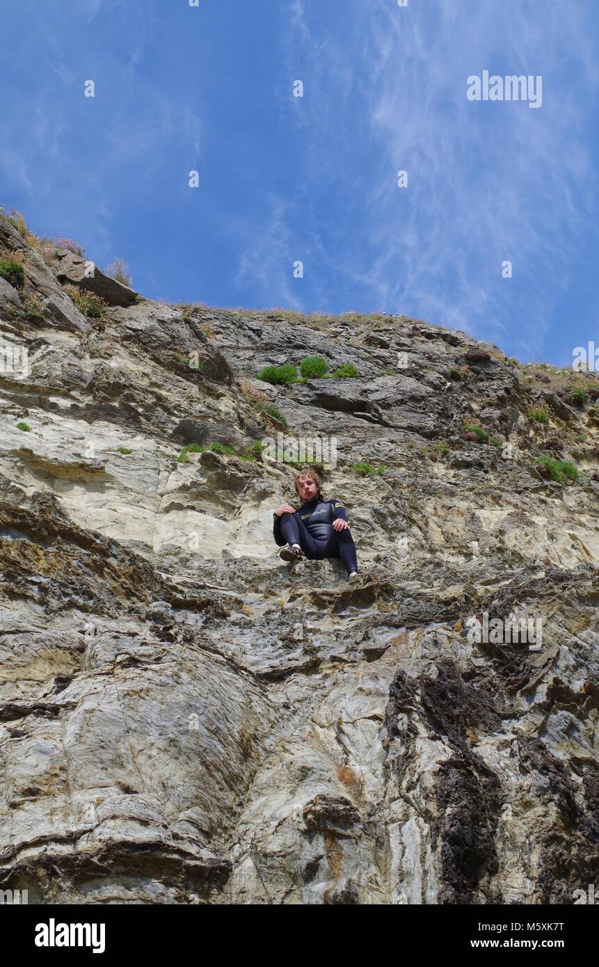 Cornish Surfer, Rock Climbing a Slate Cliff in a Wetsuit. Holywell Bay