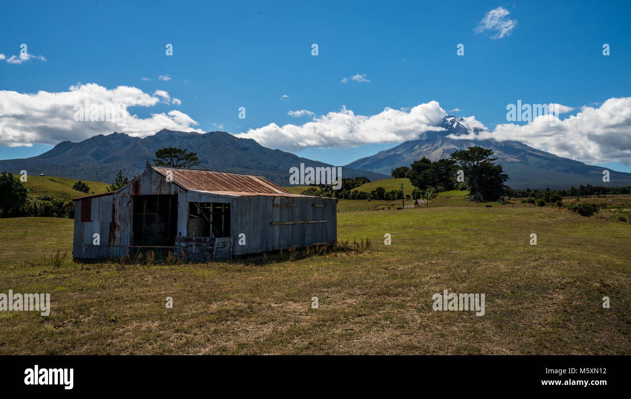 Old rusty hut in front of Mount Taranaki Volcano, New Zealand Stock Photo