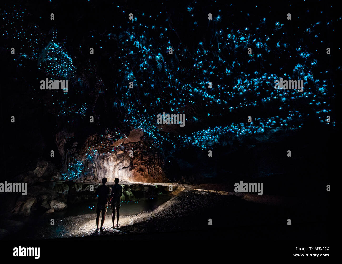 Couple standing under sky of Glowworms in Waipu Caves,New Zaland Stock Photo