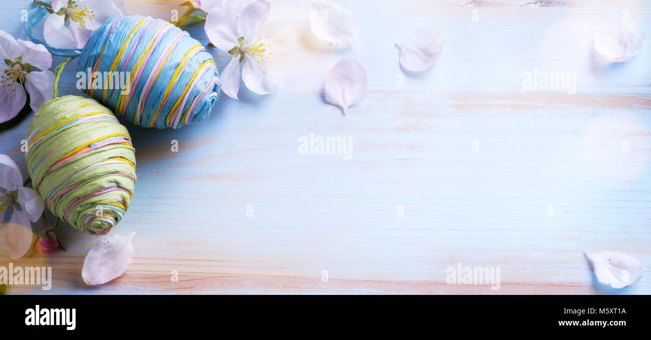 Happy Easter; Easter eggs and sprig flowers on blue table background ...