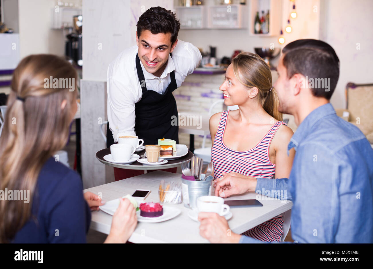 Male is bringing drinking and desserts to clients of cafe Stock Photo ...