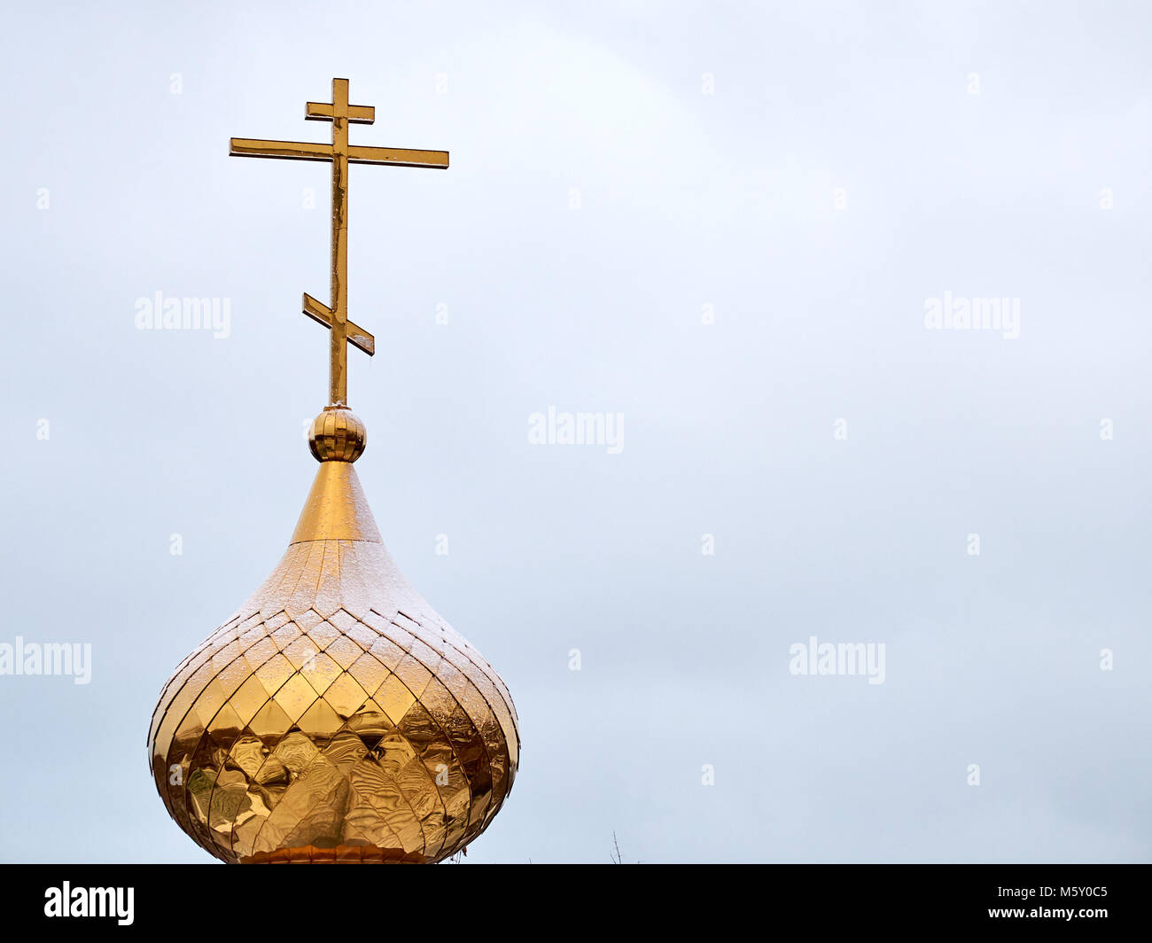 Golden metal dome with a cross on top of the christian church Stock Photo