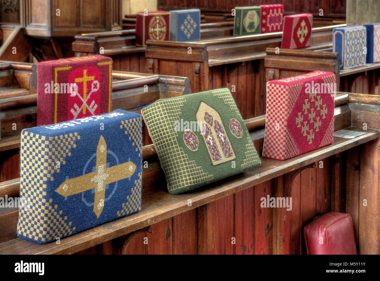Embroidered kneelers, prayer cushions or hassocks in the village church, Harrington, UK Stock
