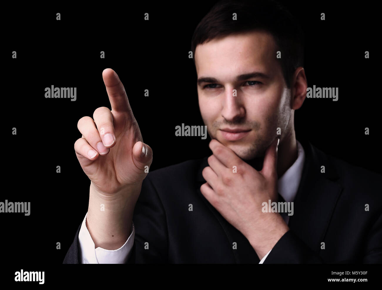 Business man pushing the imaginary  button. Isoladed on black. Stock Photo