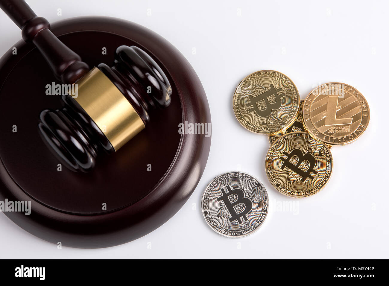 crypto currency. Golden Bitcoin, Litecoin with a wooden judges gavel on  white background Stock Photo - Alamy
