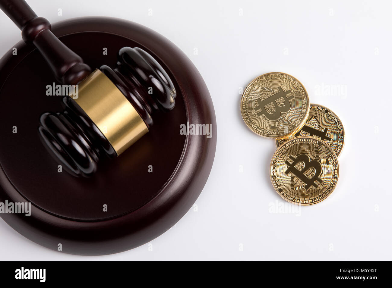 crypto currency, golden bitcoin with a wooden judges gavel on white background Stock Photo