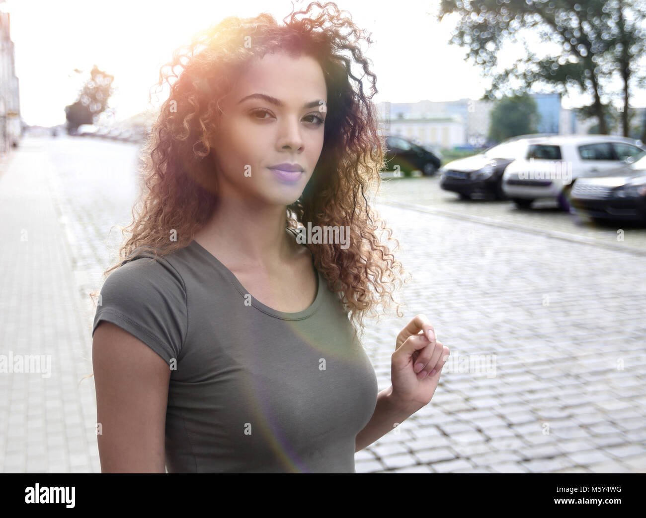 Young woman with afro hairstyle smiling in urban background Stock Photo ...