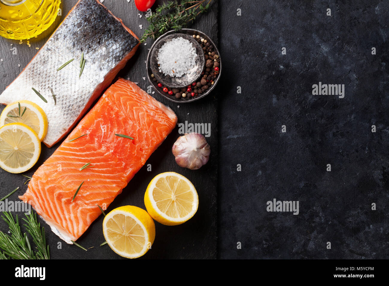Raw salmon fish fillet with spices cooking on cutting board. Top view ...