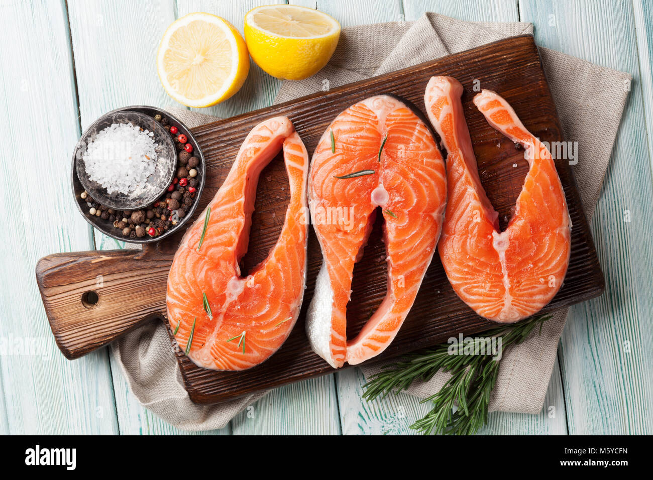 Raw salmon fish fillet with spices cooking on cutting board. Top view ...