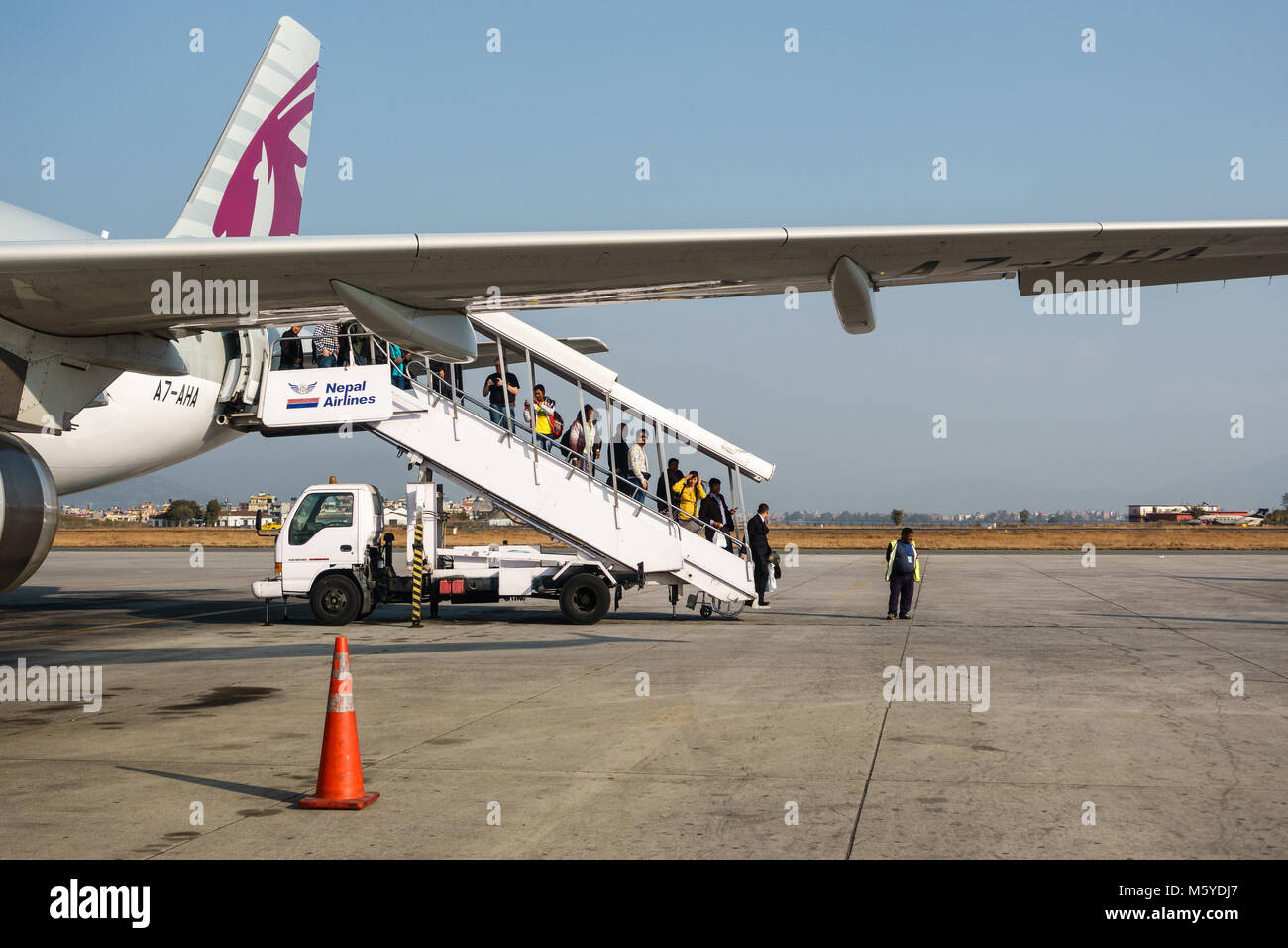 KATHMANDU, NEPAL - CIRCA JANUARY 2018: Passengers disembarking from a Qatar Airways flight at Tribhuvan International Airport. Stock Photo