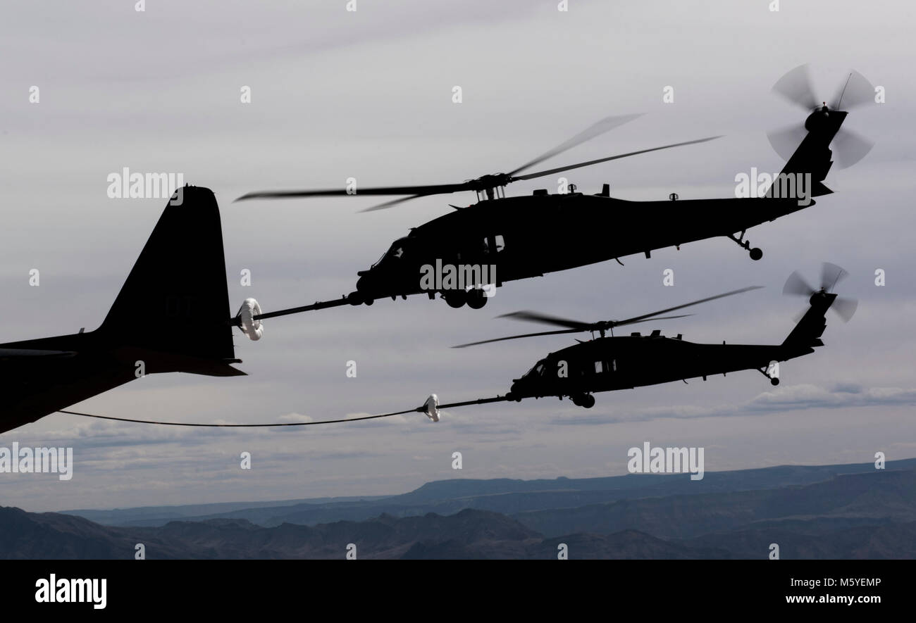 A pair of HH-60 Pave Hawk helicopters receive fuel from a HC-130J Combat King II cargo aircraft during a training mission over the Nevada Test and Training Range Feb. 22, 2018. The primary mission of the HH-60G is to conduct day or night operations in hostile environments to recover isolated personnel during war. (U.S. Air Force photo by Senior Airman Kevin Tanenbaum) Stock Photo