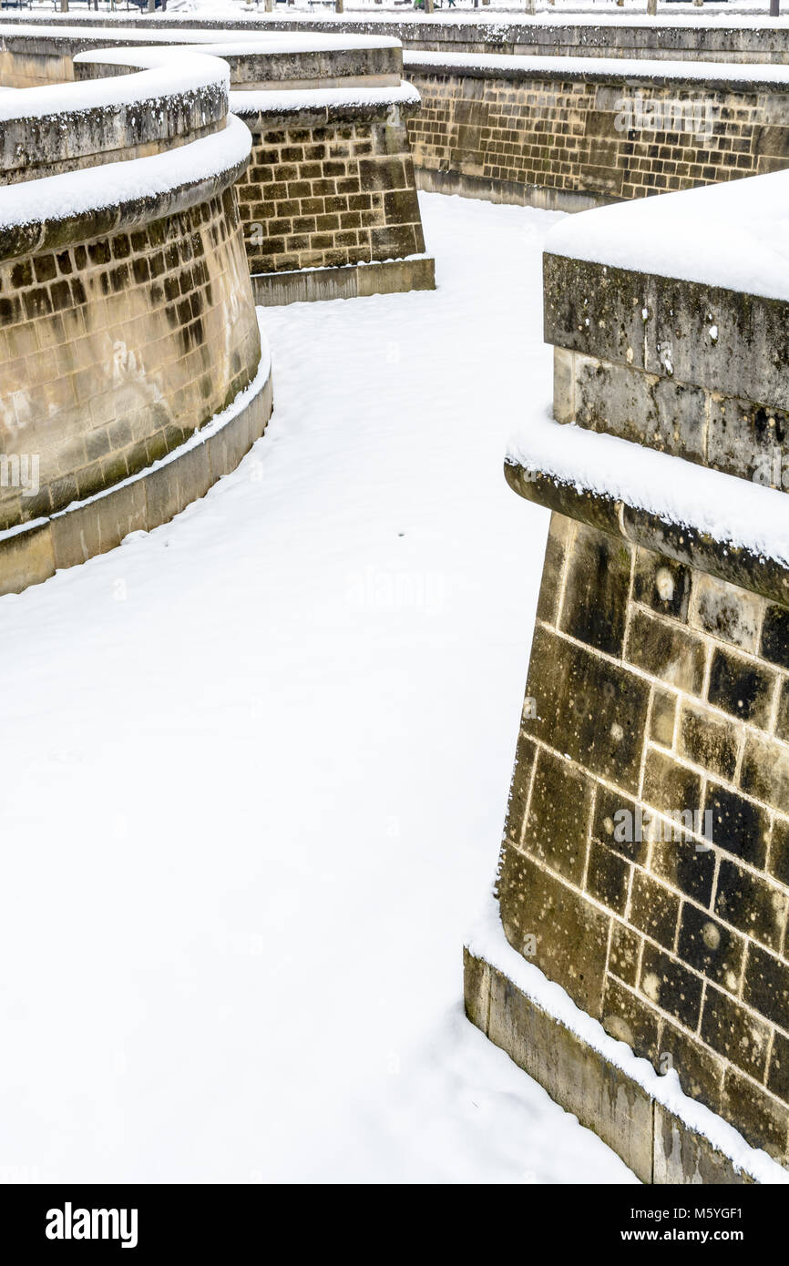 The ditch and imposing surrounding wall around the Hotel des Invalides in Paris covered in snow on a winter day. Stock Photo