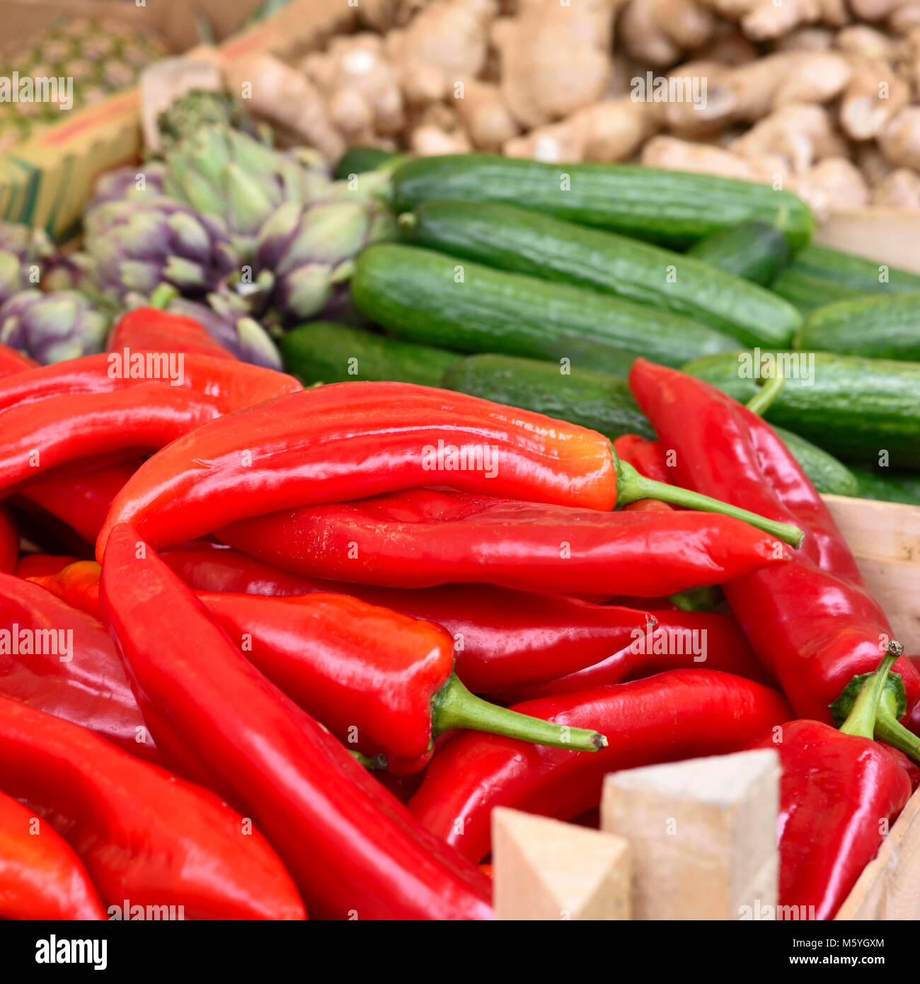 Fresh vegetables on a street market stall. red bell pepper, garlic, cucumber and ginger, arrangement on a farmers market. Stock Photo