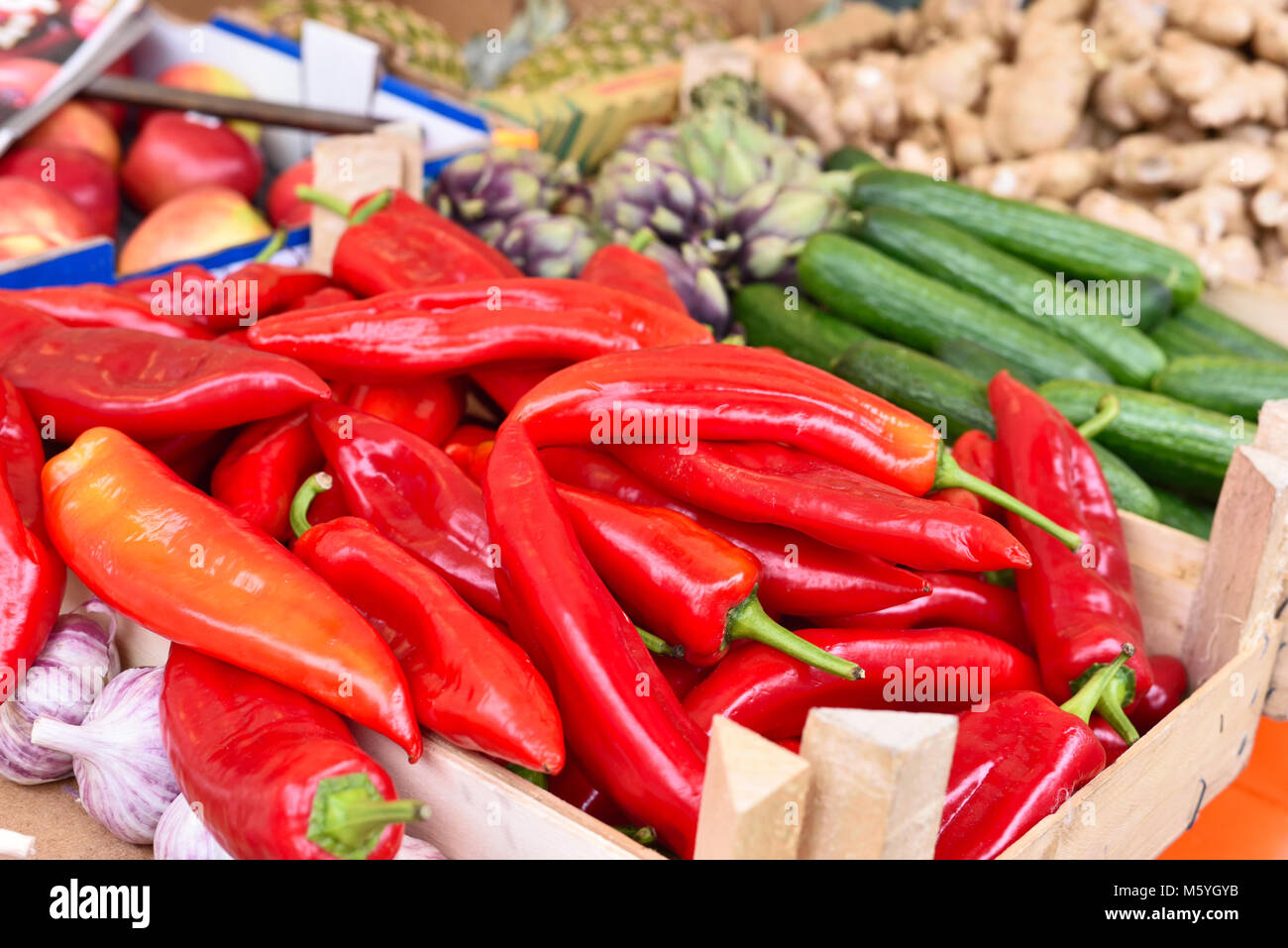 Fresh vegetables on a street market stall. red bell pepper, garlic, cucumber and ginger, arrangement on a farmers market. Stock Photo