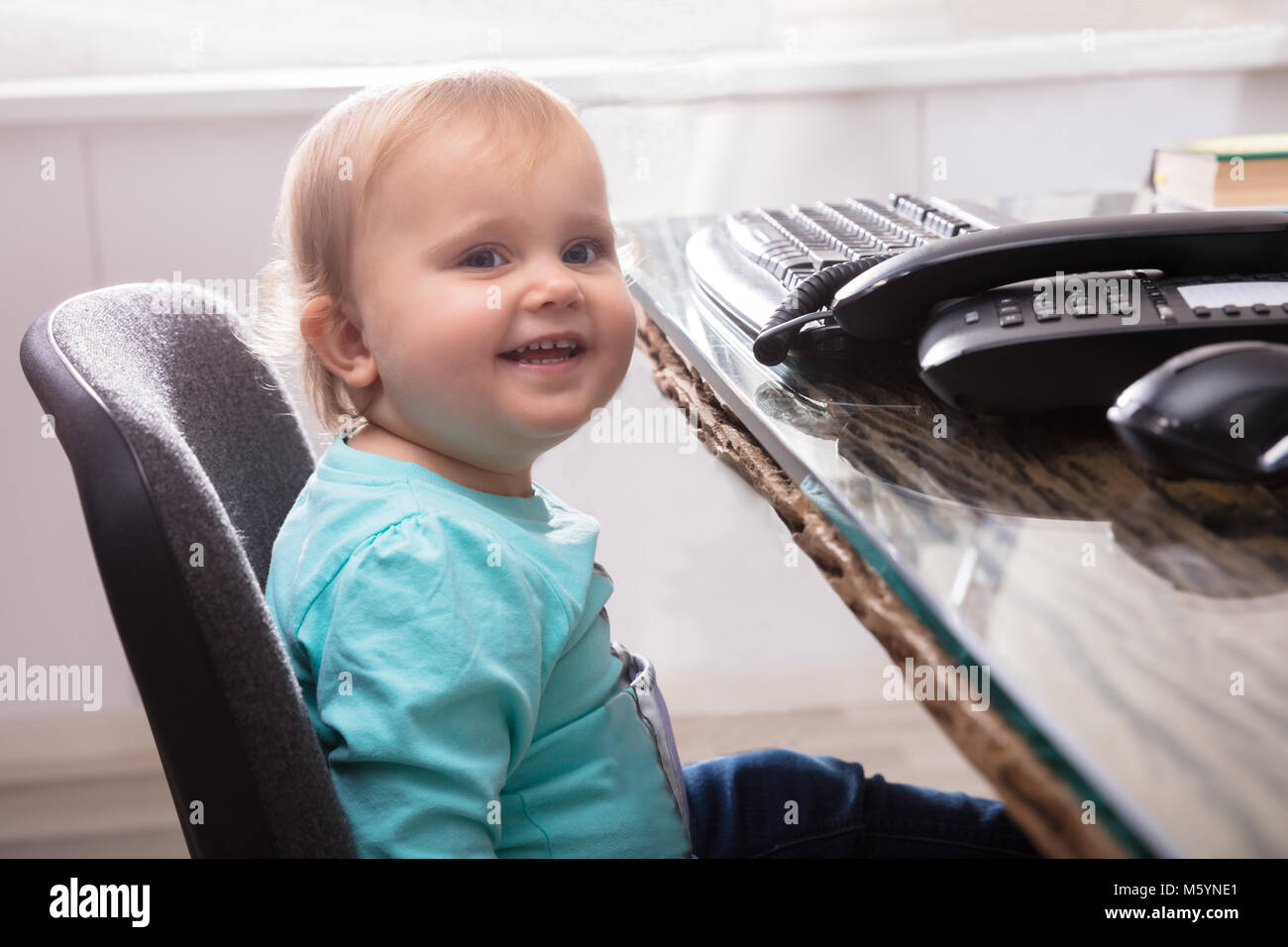 Portrait Of Cute Smiling Baby Girl Sitting On Chair Stock Photo - Alamy