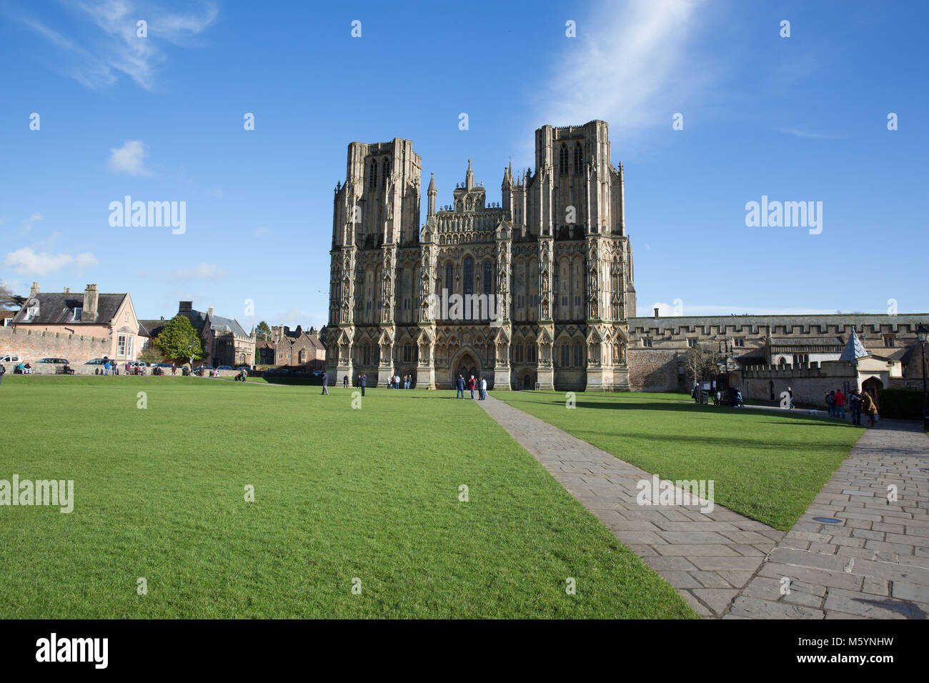 Wells Cathedral Somerset in spring sunshine and blue sky with visitors Stock Photo