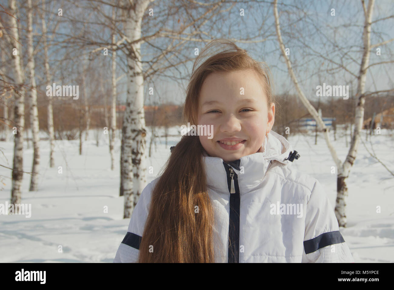 Portrait of plump teen girl between the trees in winter Stock Photo
