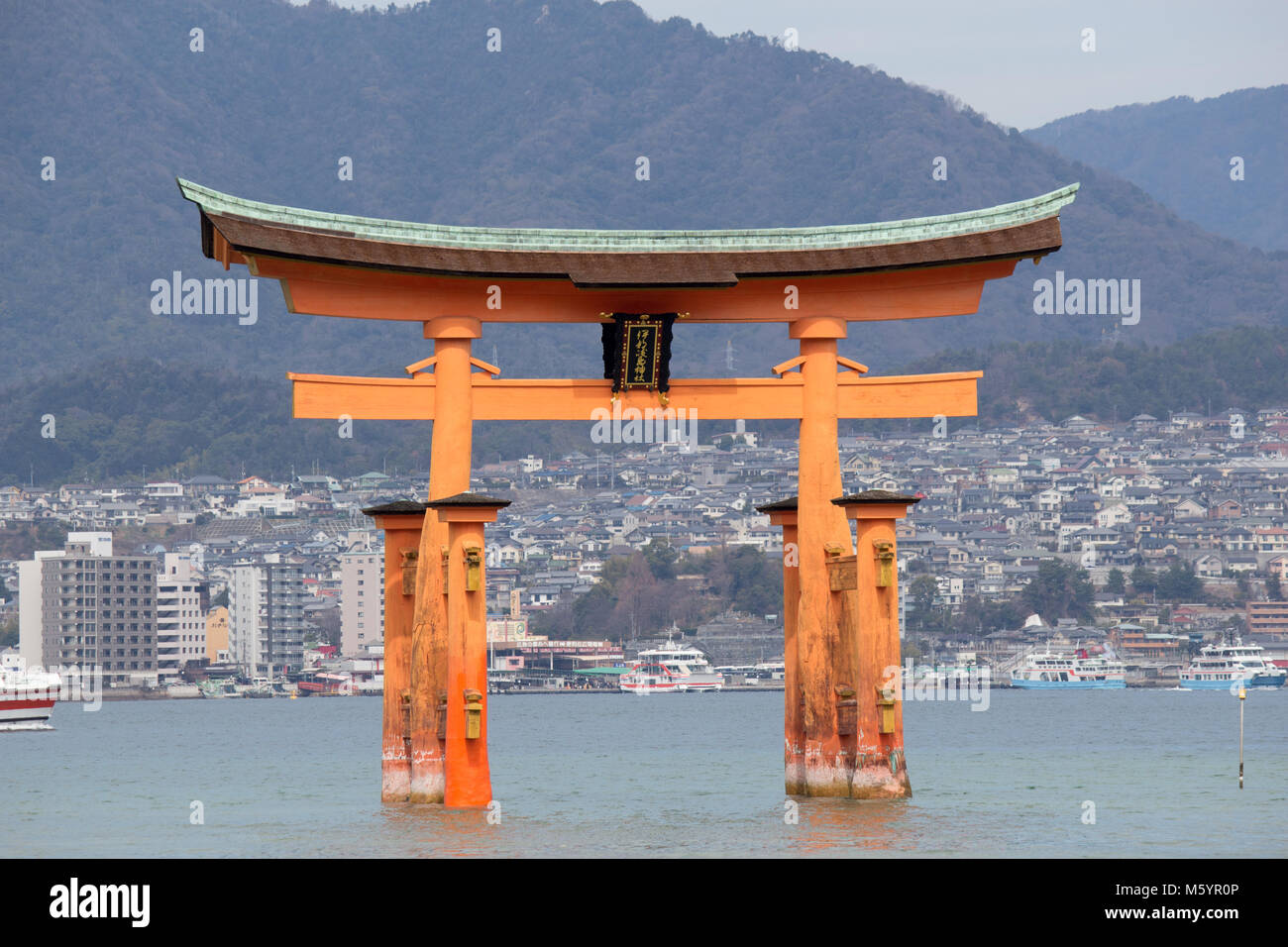 Itsukushima, also known as Miyajima, is a small island in Hiroshima Bay.Just offshore is the giant, orange Great Torii Gate. Stock Photo