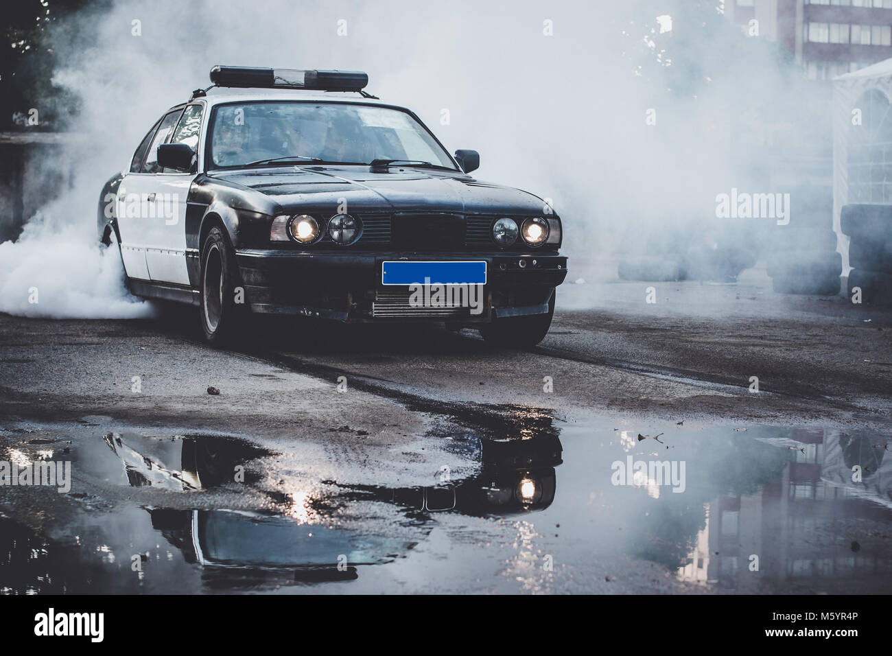 Police car on drift racing motorsport. German driftcar burning tires on asphalt in drift-show. Speed, drive and active sport Stock Photo
