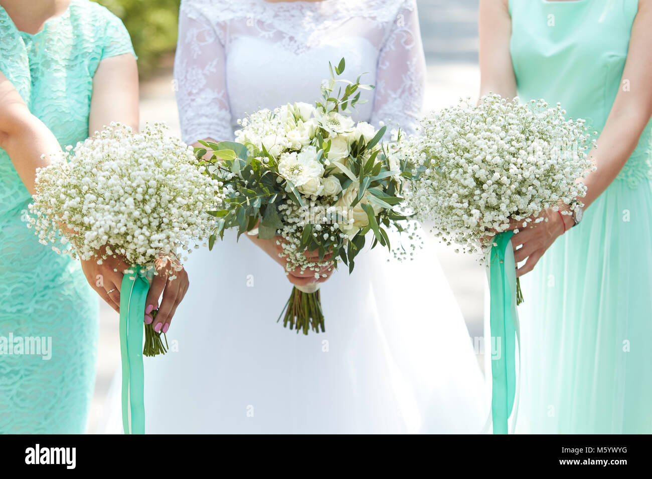 bride and bridesmaids holding in their hands bouquets of flowers M5YWYG