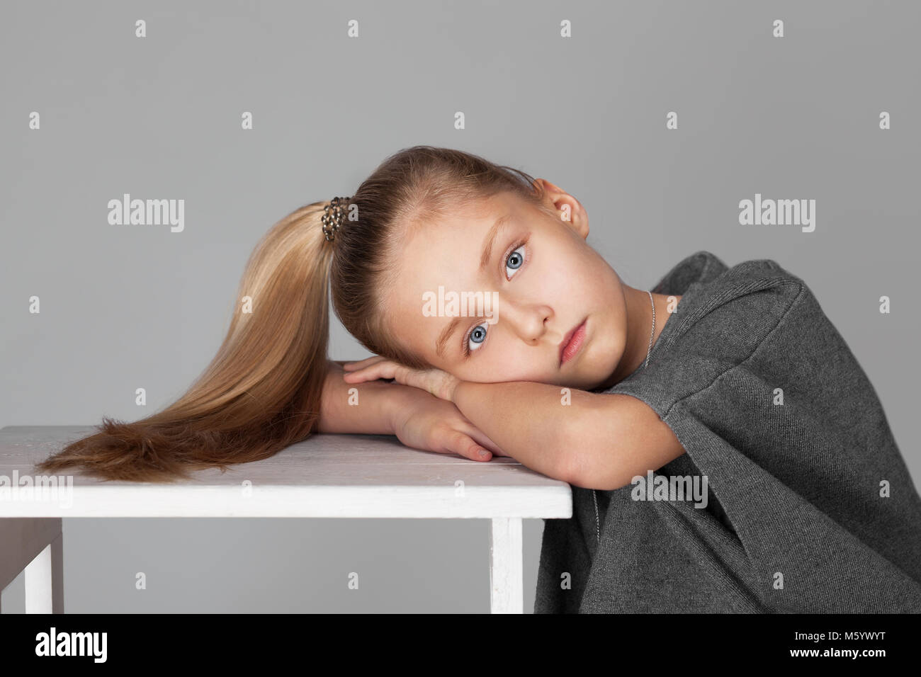 Portrait of a cute girl with long hair in the photostudio on grey ...