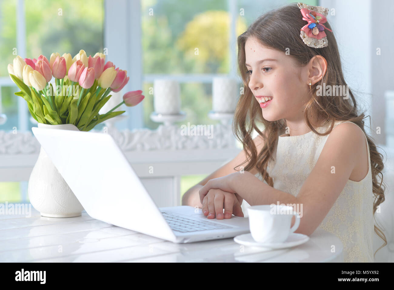 Cute little girl with modern laptop Stock Photo - Alamy