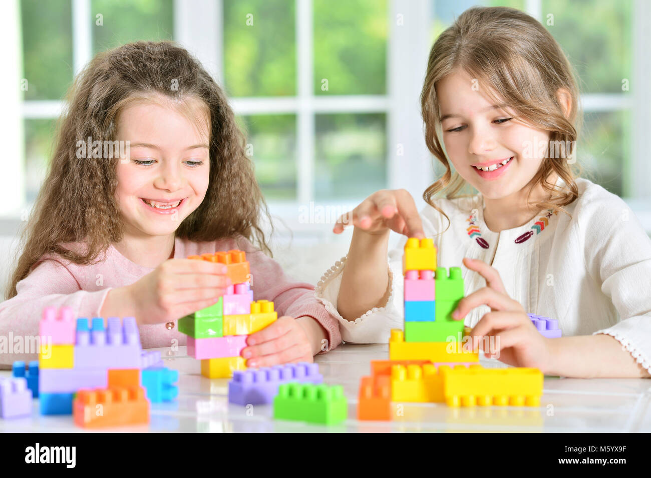 little girls playing with plastic blocks Stock Photo - Alamy