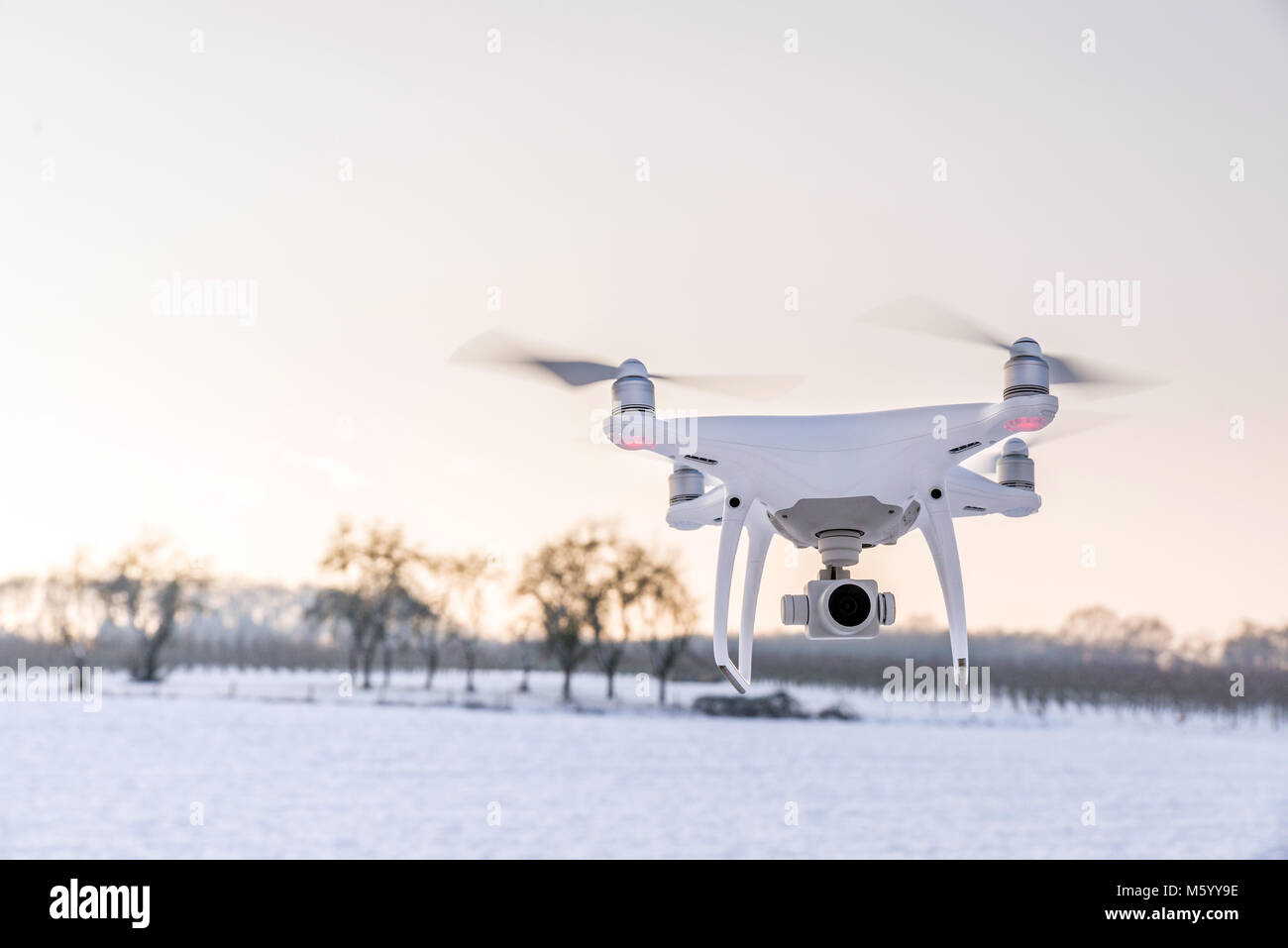 Photo of a flying white professional quadcopter drone camera in the air ...