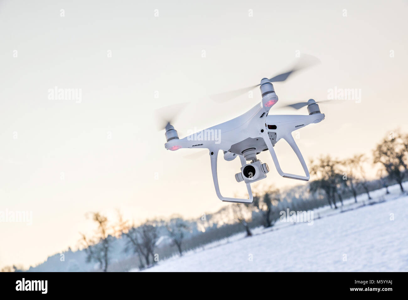 Photo of a flying white professional quadcopter drone camera in the air ...