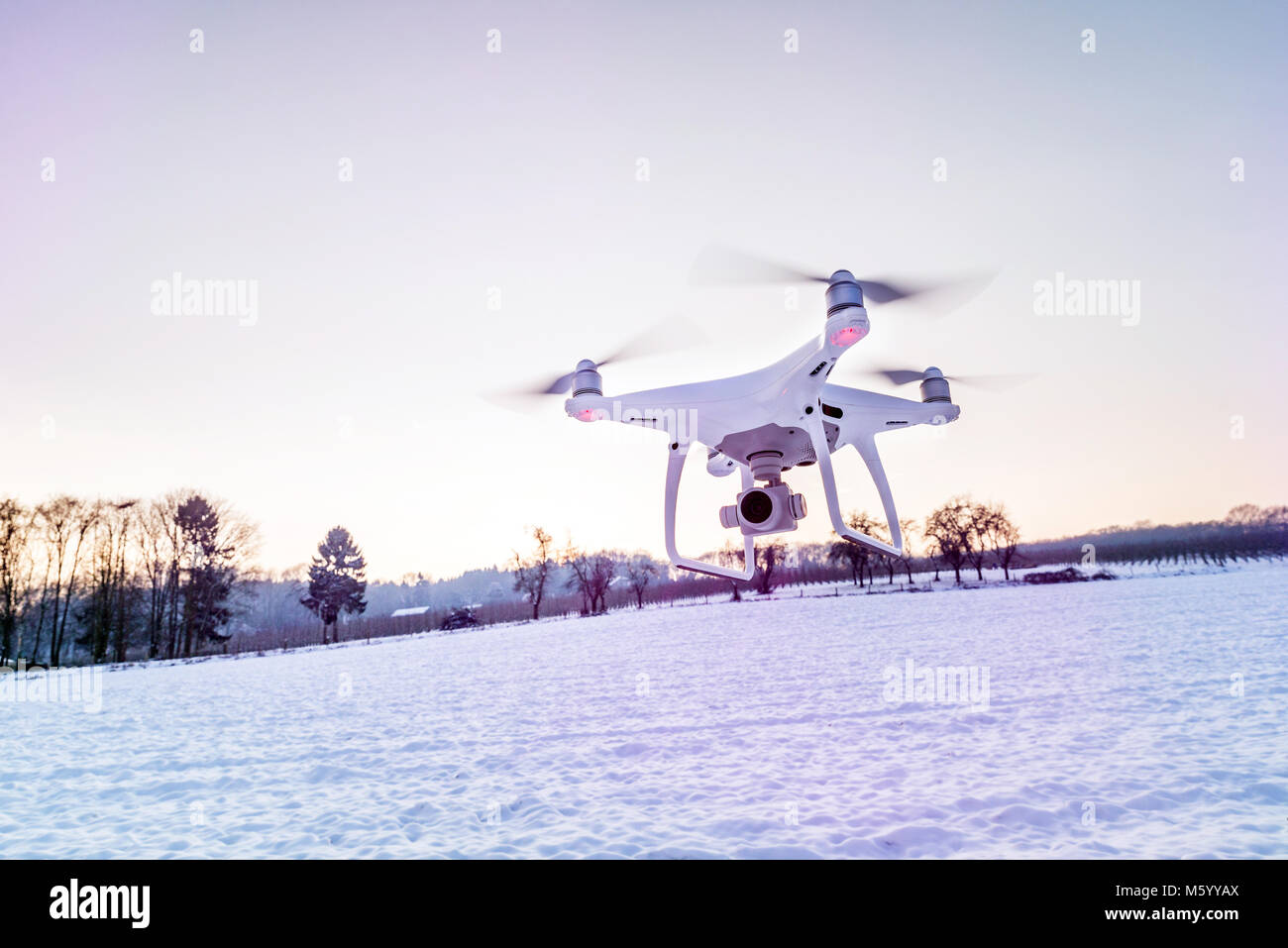 Photo of a flying white professional quadcopter drone camera in the air ...