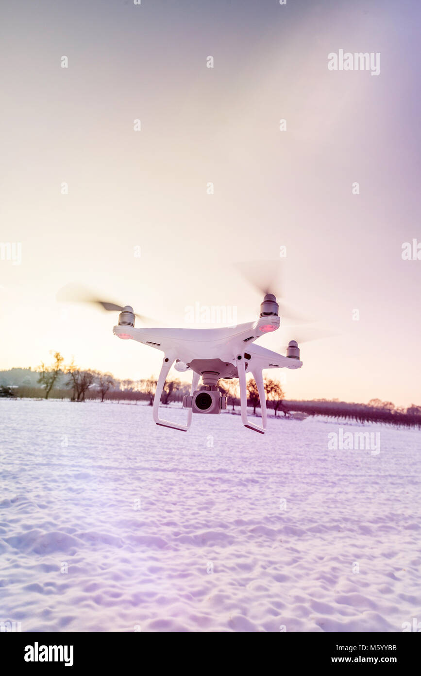 Photo of a flying white professional quadcopter drone camera in the air ...