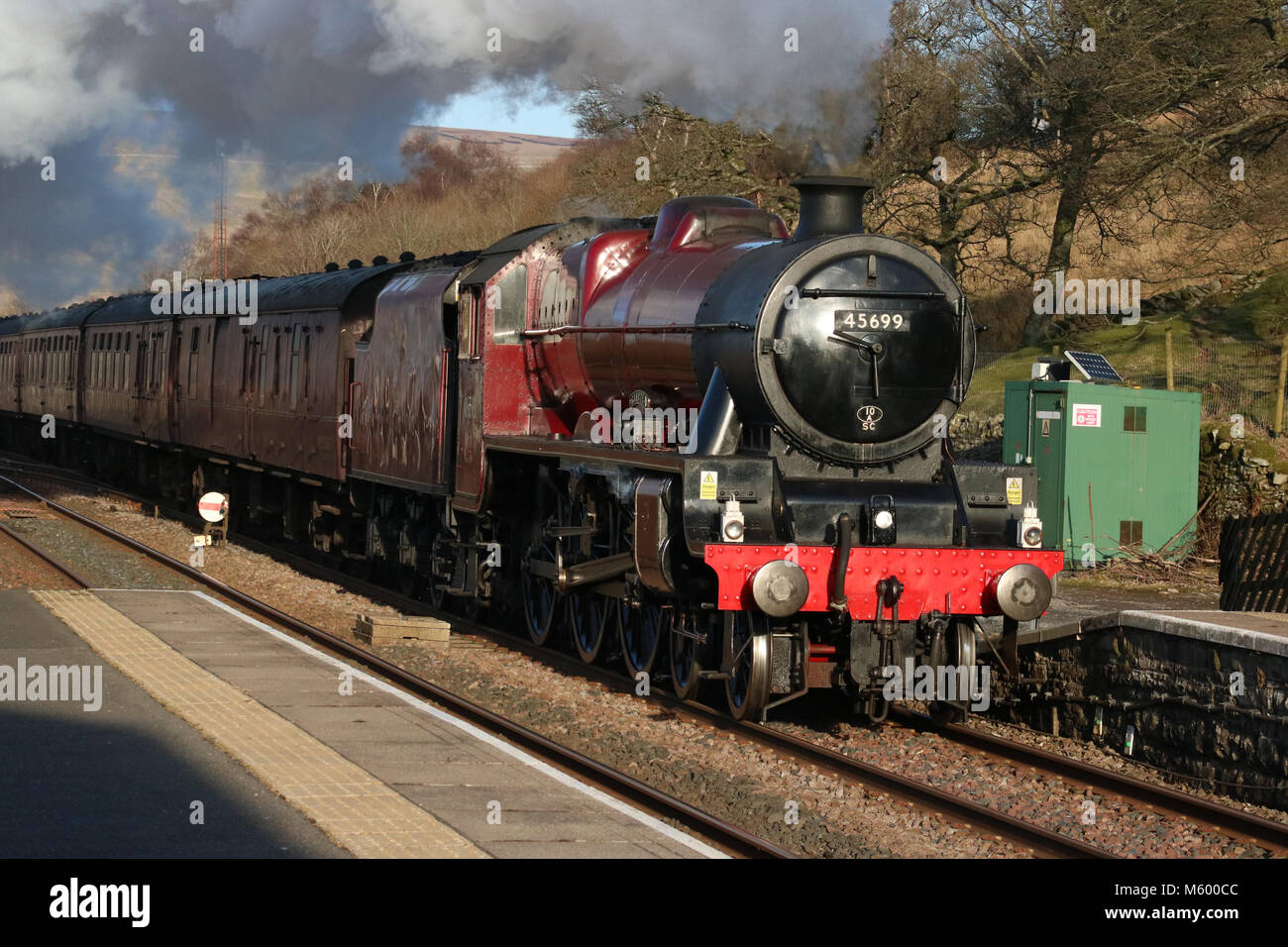 Preserved steam locomotive 45699 Galatea heading through Garsdale station on the Settle to Carlisle railway line with the Cumbrian Mountain Express. Stock Photo