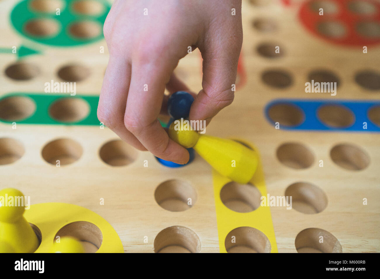 Child playing Ludo board game. Close-up view. Stock Photo