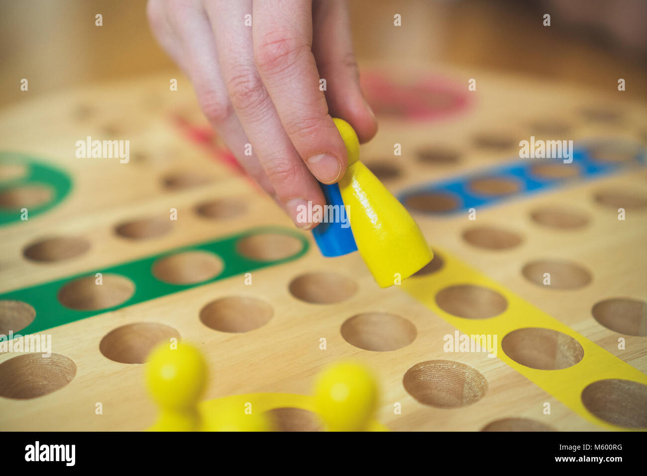 Child playing Ludo board game. Close-up view. Stock Photo