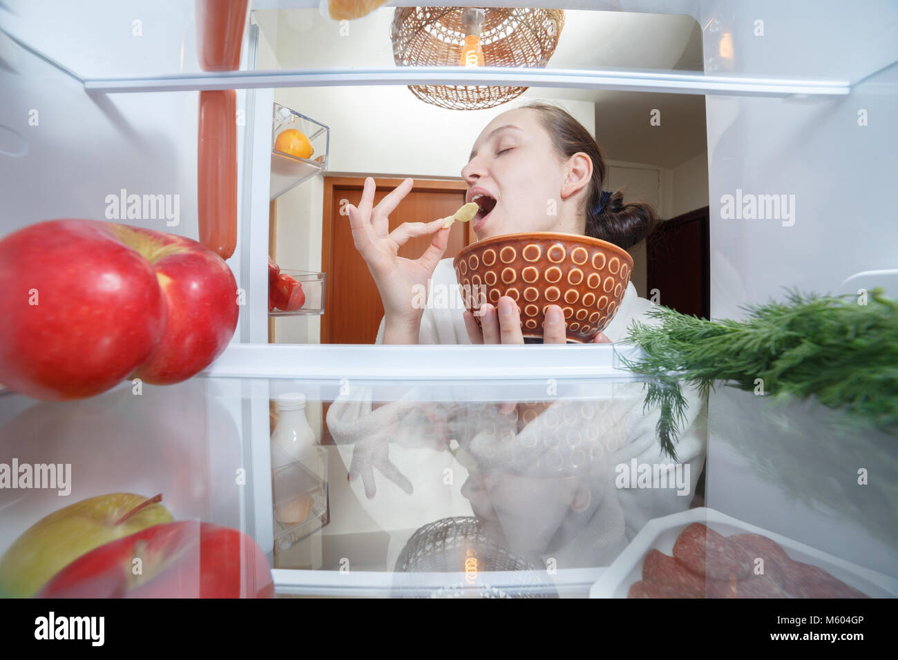 happy young woman eating chips inside refrigerator Stock Photo Alamy