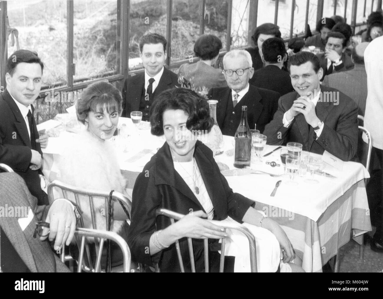 Wedding relatives happy eating during a 1960s 1970s wedding in Italy. Black and white shot. Stock Photo