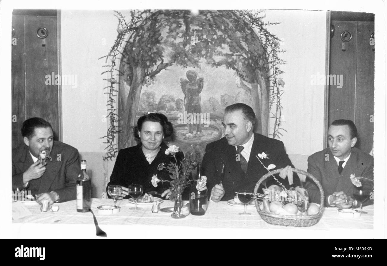 Wedding relatives happy eating during a 1960s 1970s wedding in Italy. Black and white shot. Stock Photo