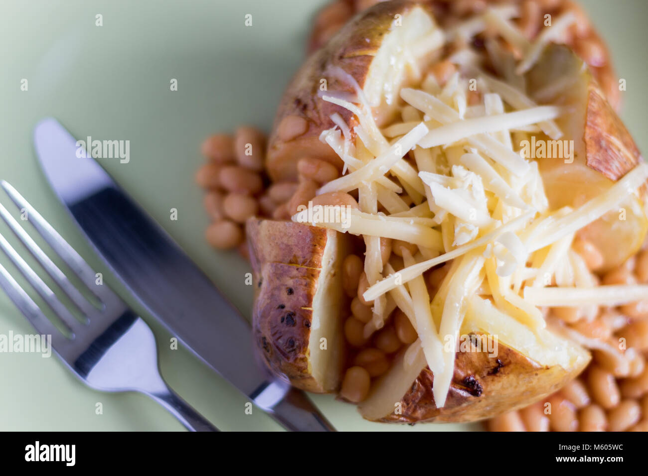 Jacket potato with baked beans and grated cheese Stock Photo Alamy