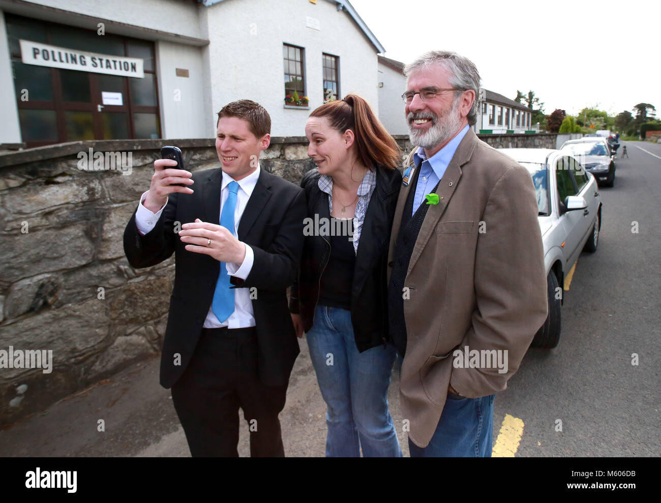 Sinn Fein's Party leader Gerry Adams joins in on a selfie with Matt Carthy, Sinn Fein's Midland & Northwest candidate and voter Lisa McArdle from County Louth outside the Doolargy National School in Ravensdale, County Louth, Ireland,  Friday May 23rd. Polling stations will remain open until 10pm. Almost 2,000 candidates are contesting the 949 local authority seats, while 41 hopefuls are in the race for 11 MEP seats spread over three constituencies while counting has begun in the local elections in Northern Ireland. Over 900 candidates are competing for the 462 seats on 11 new local authorities Stock Photo