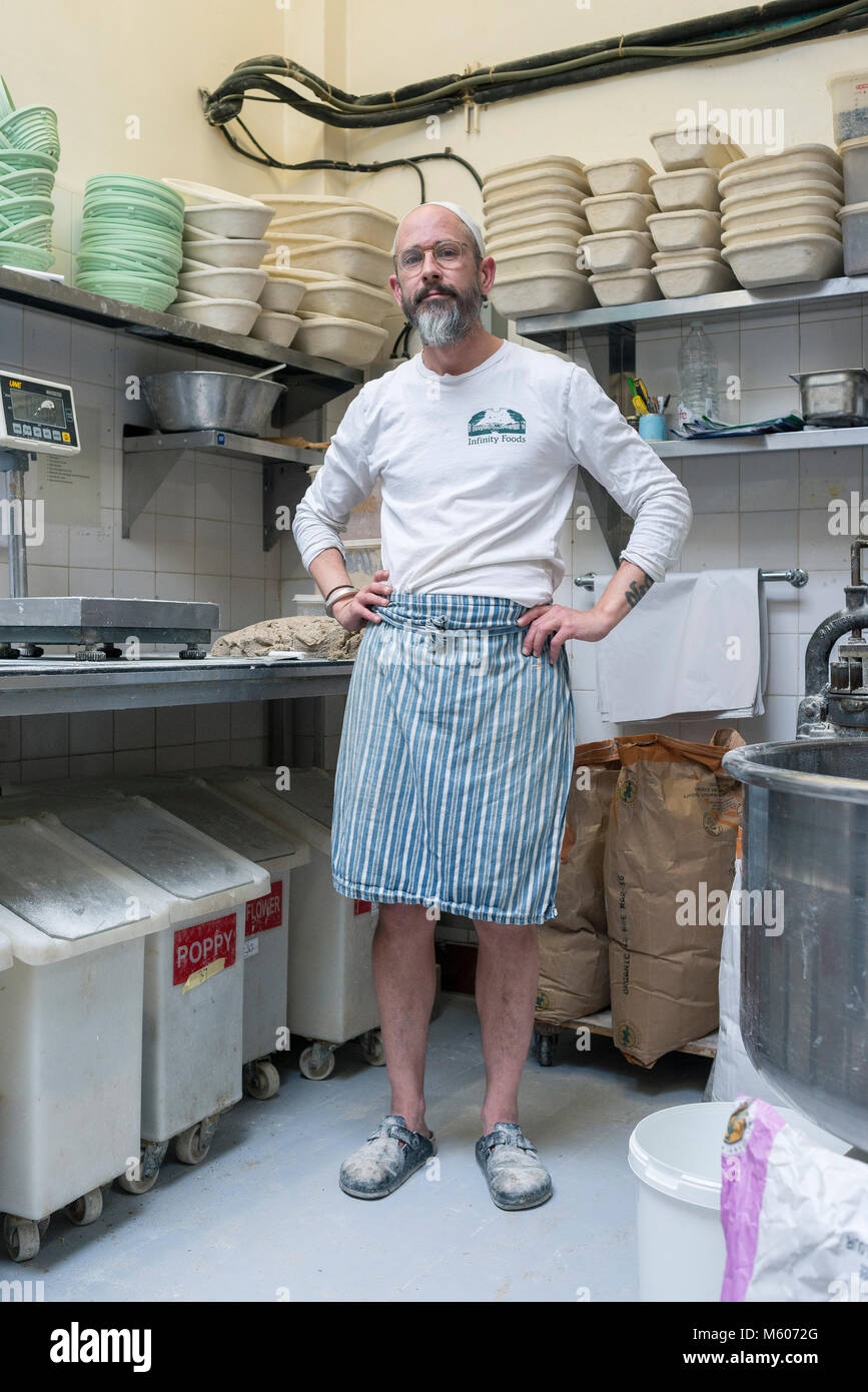 the head baker of infinity foods in brighton stands in his kitchen