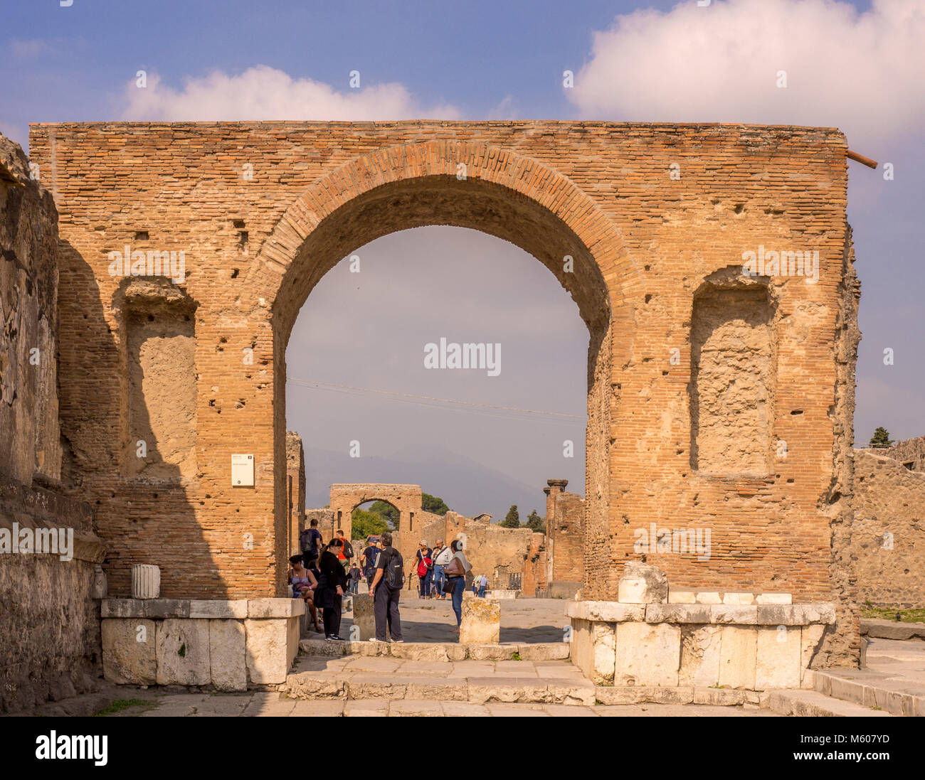 Honorary arches and tourists at the Pompeii ruins, Italy. Stock Photo