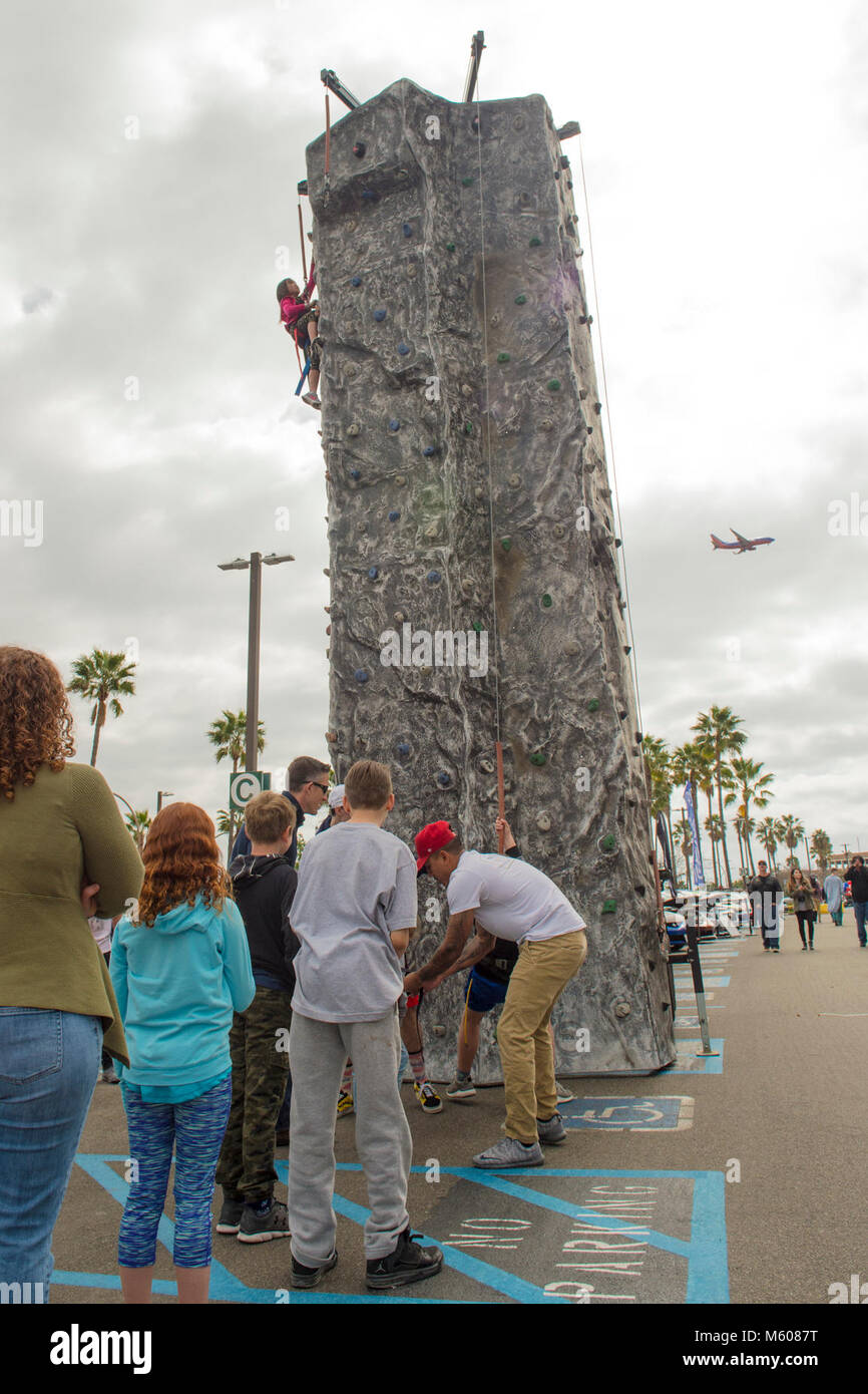 SAN DIEGO (Feb. 10, 2018) Onlookers watch as Maddy Maclan, 9, decends from a rock-climbing wall during an appreciation day for staff, patients and families. The Gary Sinise Foundation hosted the Annual Gary Sinise Invincible Spirit event, which featured a performance by the Lt. Dan Band, a barbecue lunch provided by Robert Irvine Foods, and multiple fun events for all ages. (U.S. Navy Stock Photo