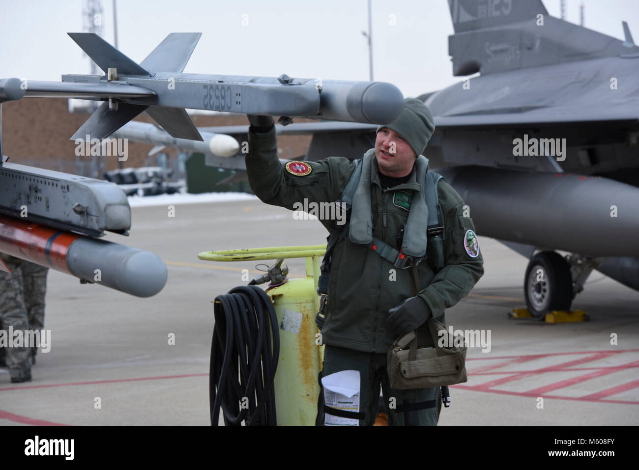 1st Lt. Travis Dancer, an F-16 Fighting Falcon pilot assigned to the 180th Fighter Wing in Swanton, Ohio, inspects his aircraft before takeoff on Jan. 7, 2018. Temperatures throughout January have reached record lows across the country. In Northwest Ohio, the wind chill has consistently been in the -10 to -20 range, even dipping close to -30 at times. Extreme weather situation such as this help prepare Airmen at the 180FW to operate in austere environments. Stock Photo