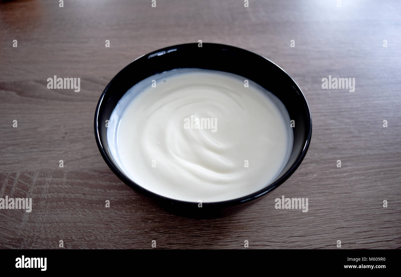 Ceramic bowl of white yogurt isolated on wooden background from above, plain yoghurt. yogurt. yoghurt Stock Photo