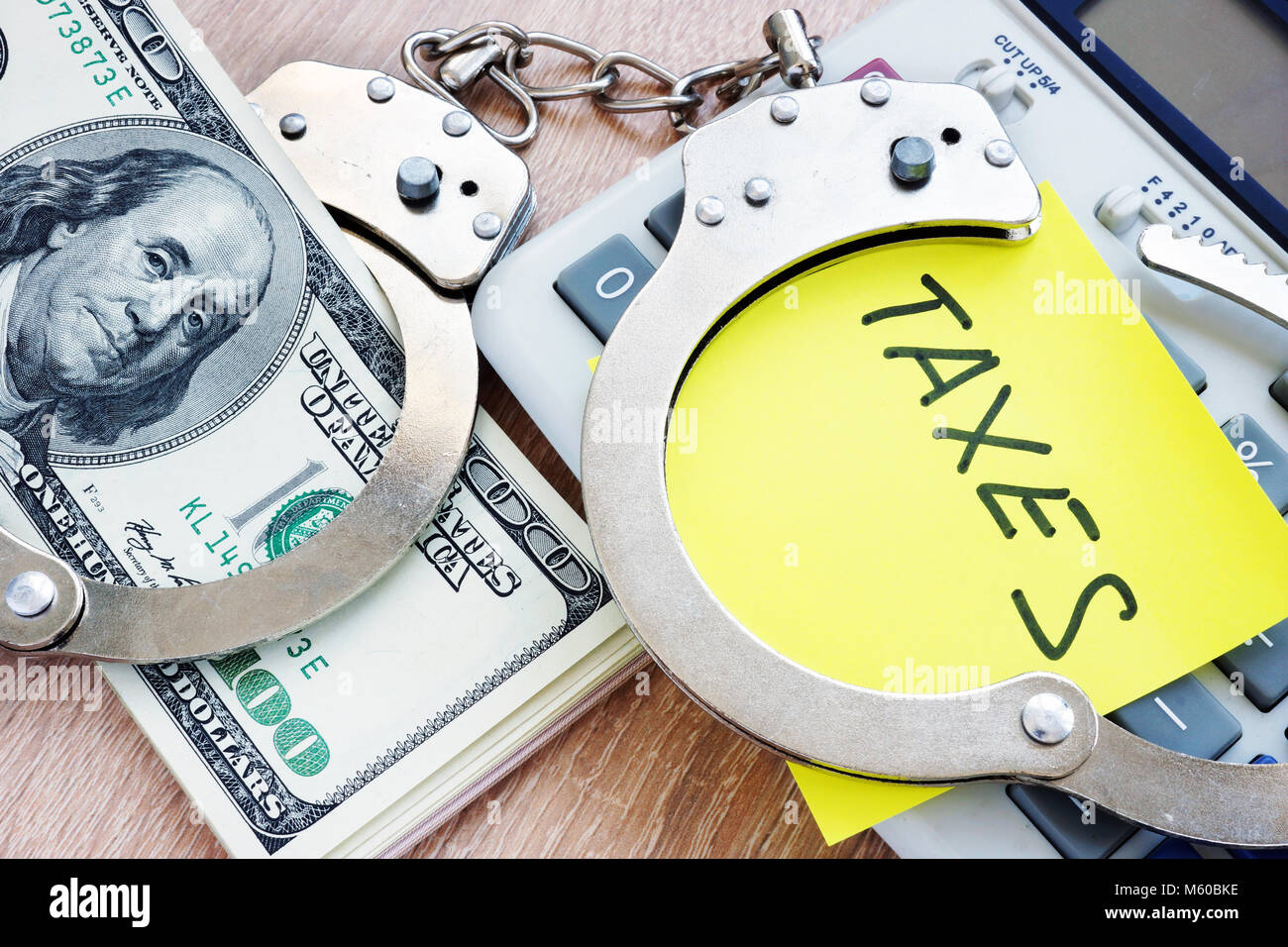 Problems with taxes. Handcuffs and money. Tax evasion concept. Stock Photo