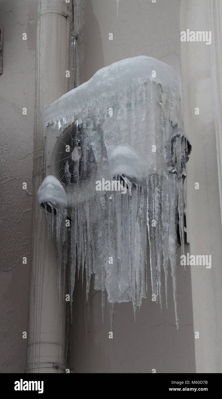 wall-mounted air conditioner frozen over as an icicle Stock Photo