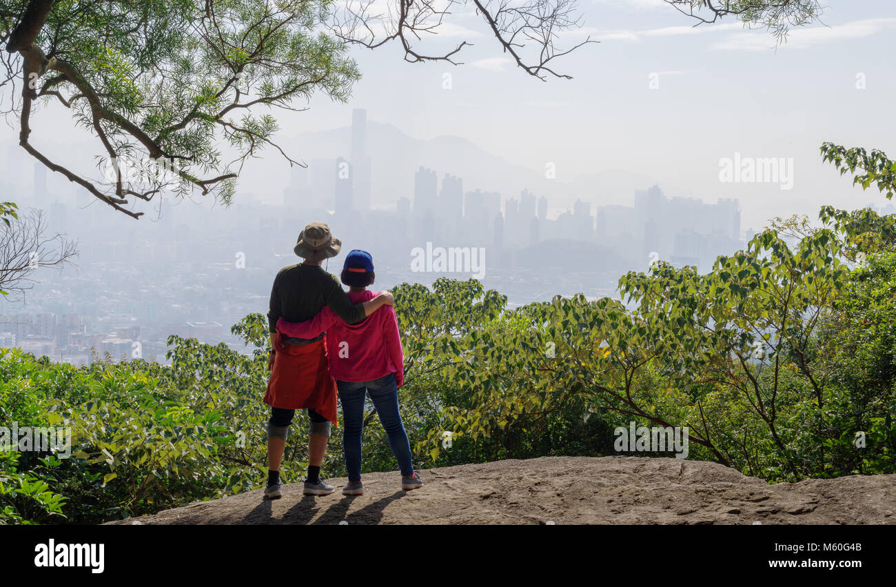 Couple looking at city view from mountains Stock Photo