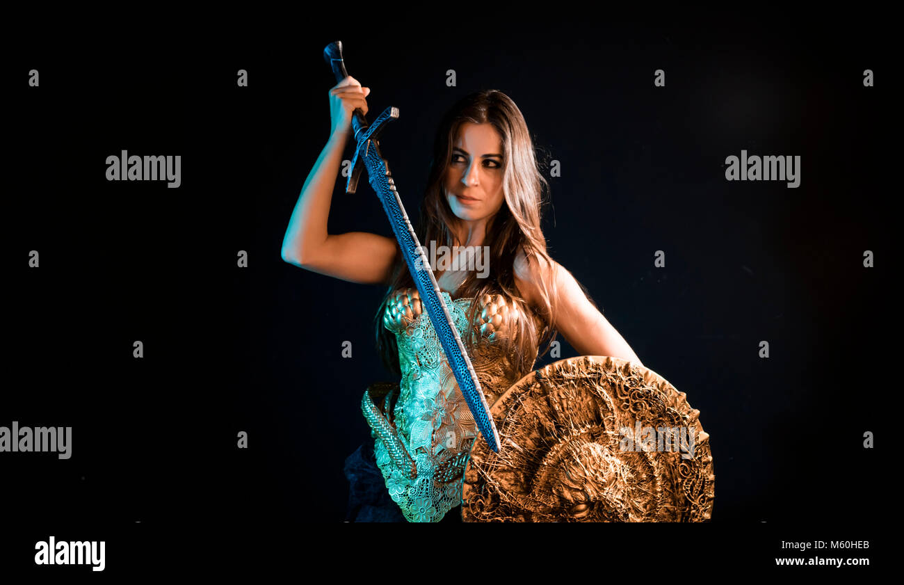 Medieval, valkyrie warrior, woman with golden armor iron coat and big warrior sword Stock Photo