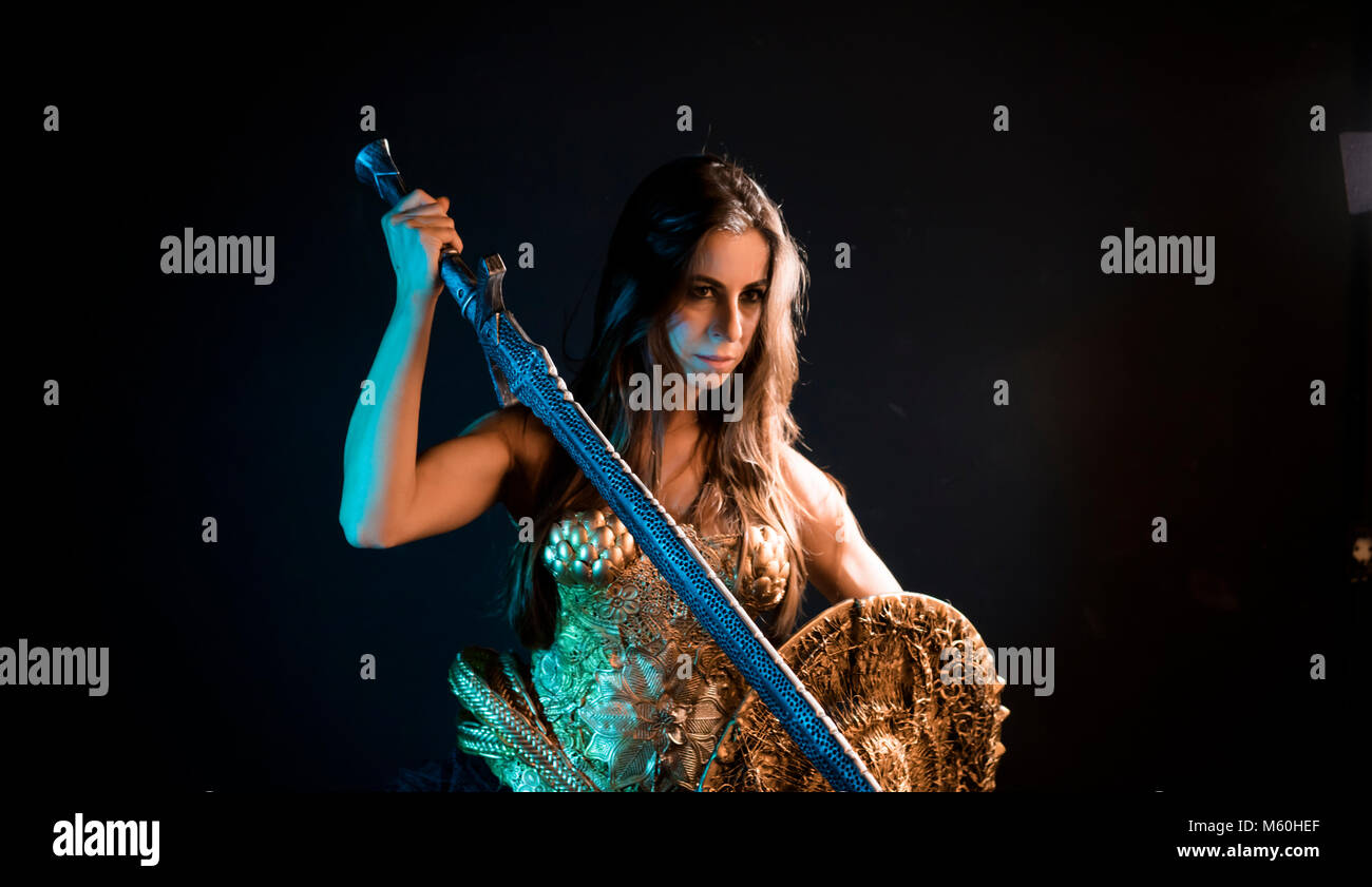valkyrie warrior, woman with golden armor iron coat and big warrior sword Stock Photo